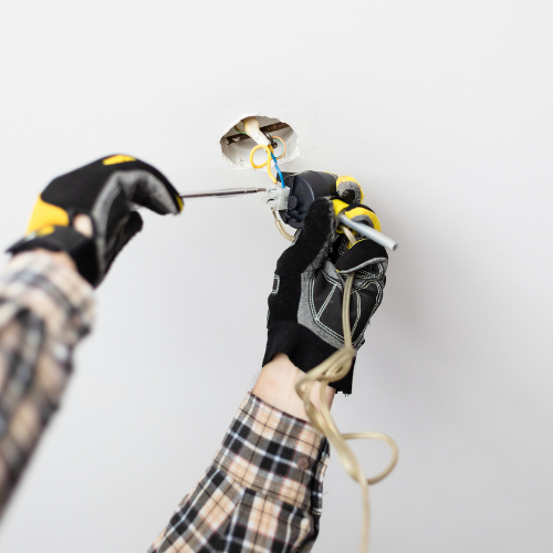 An electrician installing a light fixture.